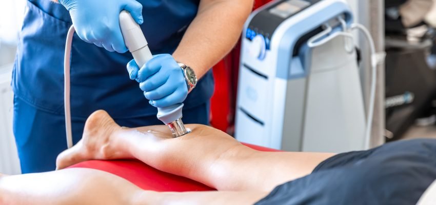 Shock wave therapy, the magnetic field, rehabilitation, physiotherapist doctor performs surgery on a patient's shin.